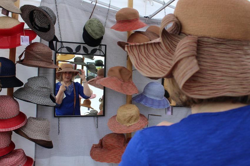 Golden's Tami Rauer tries on a hat by fiber artist Diane Harty during the Golden Fine Arts Festival Aug. 20 in downtown Golden.